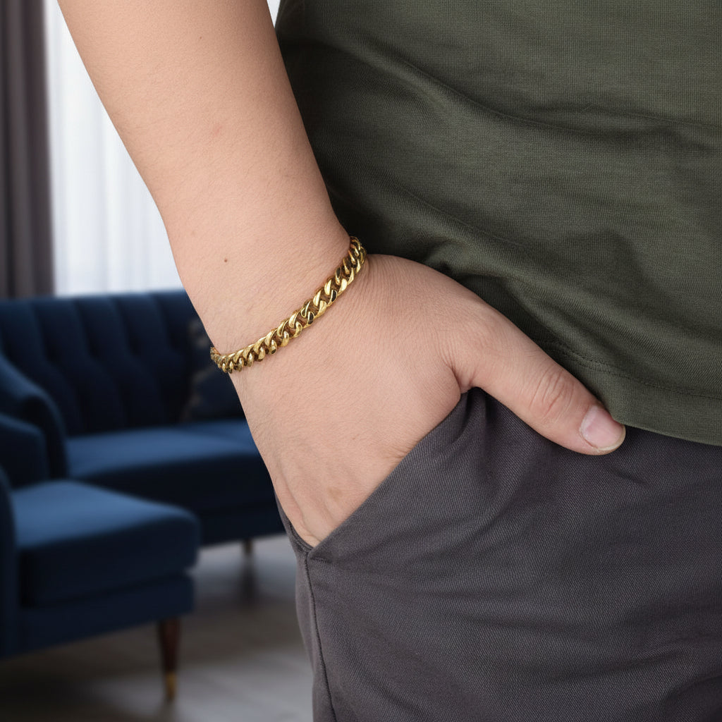 Gold curb link bracelet worn by man with relaxed everyday styling