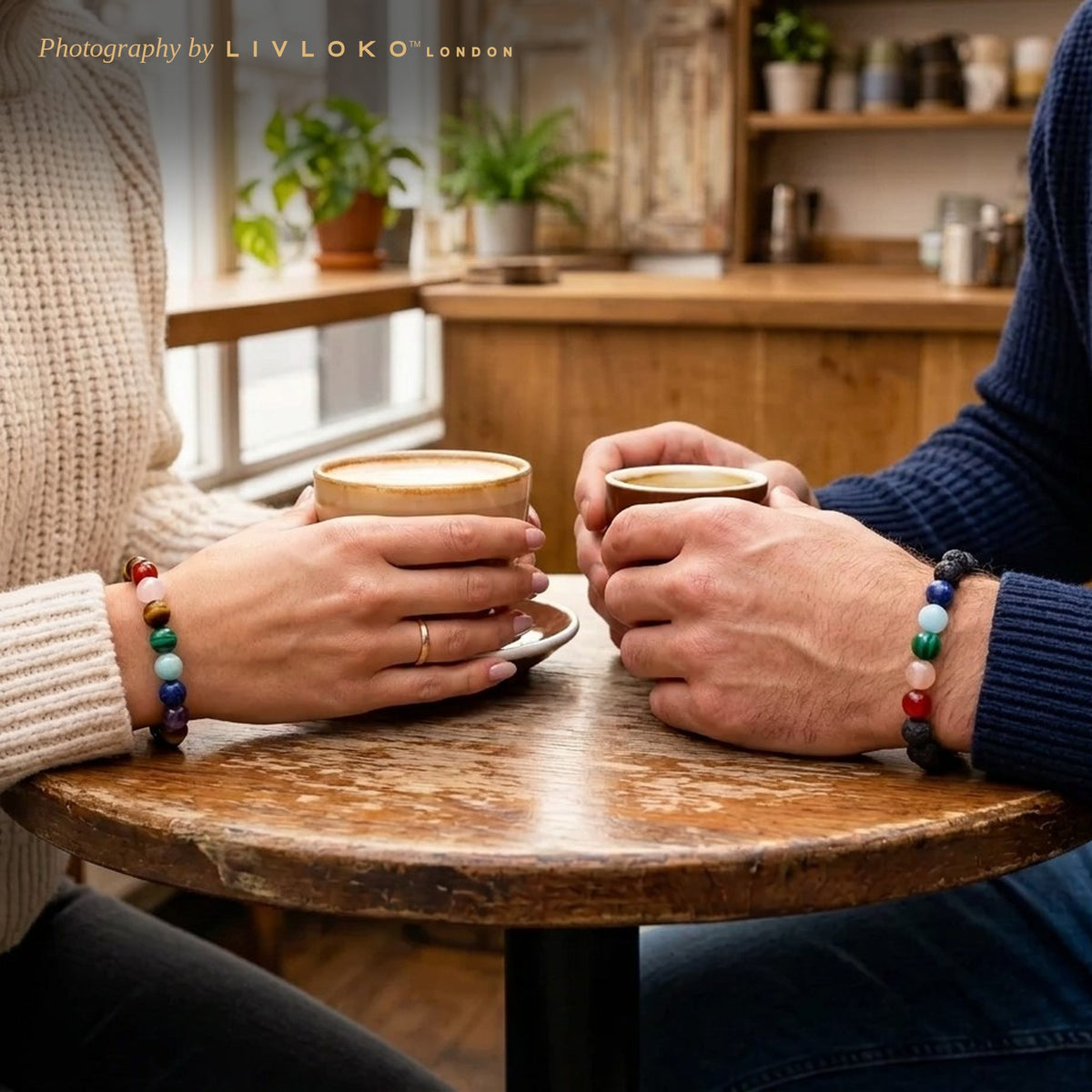 Couple wearing the Livloko London 7 chakra matching bracelets over coffee in a London café