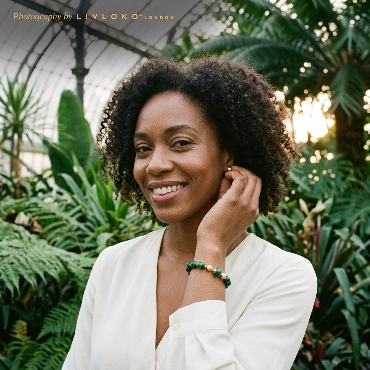 Woman wearing the Livloko London green malachite gold plated bracelet in the Palm House at Kew Gardens, London
