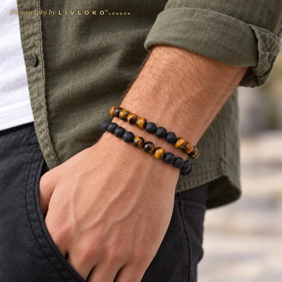 Men's tiger eye and lava stone beaded bracelet set worn on the wrist with an olive shirt