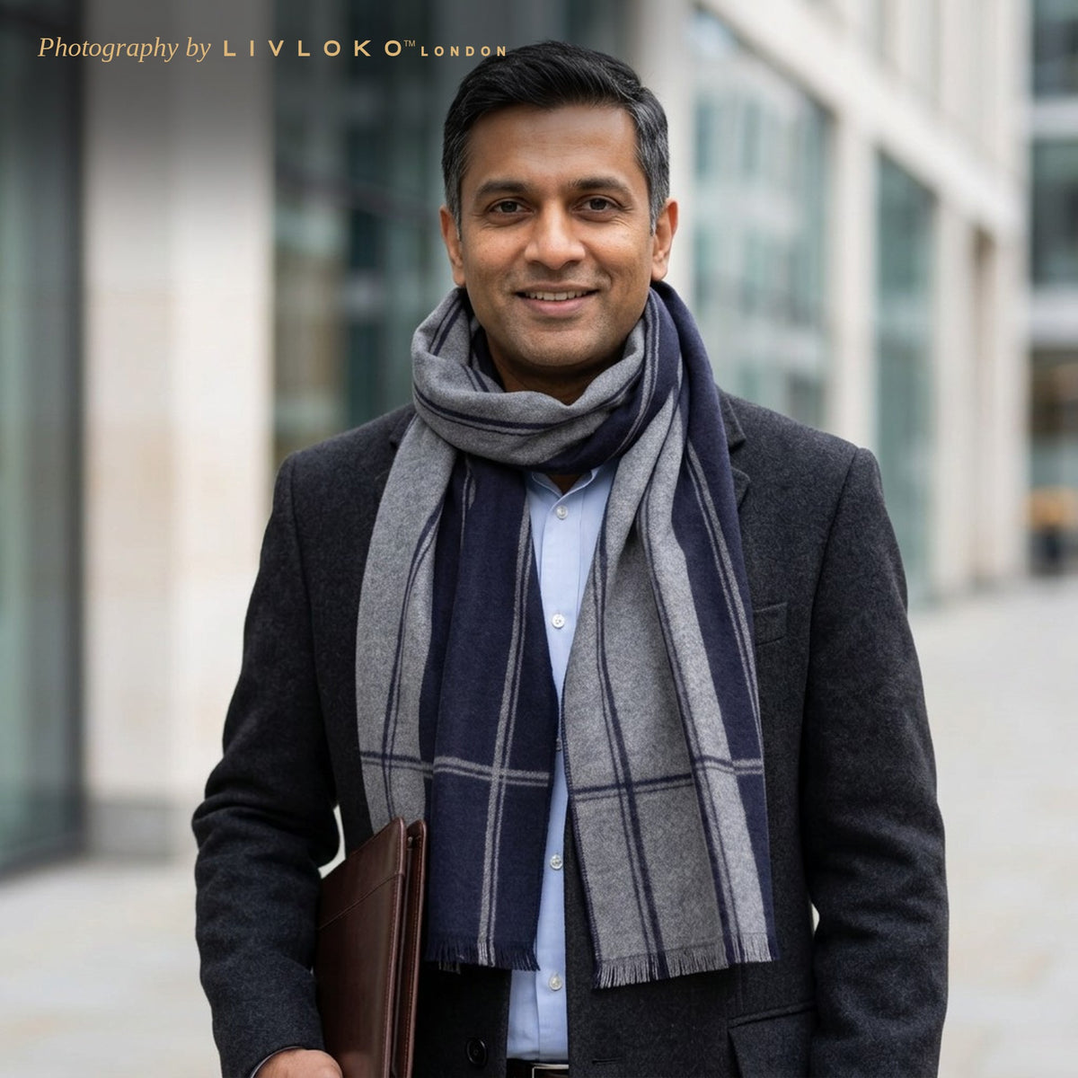 Man wearing the Livloko London men's navy and grey striped wool scarf with a charcoal coat in London