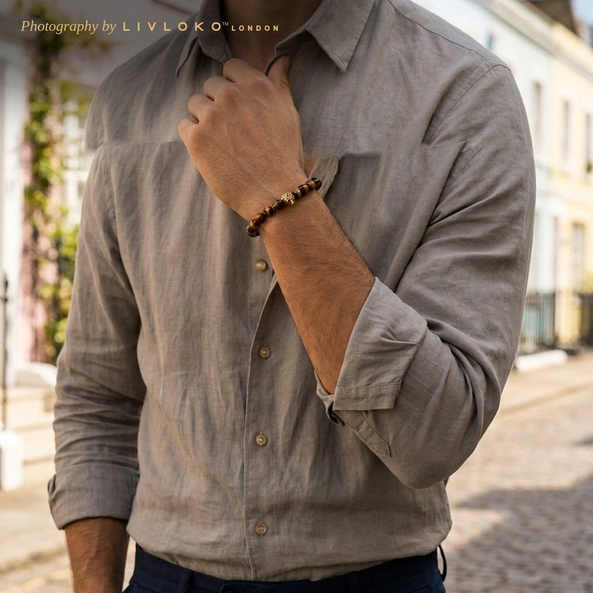 Man in a linen shirt wearing the men's tiger eye bracelet with leopard charm in Notting Hill, London