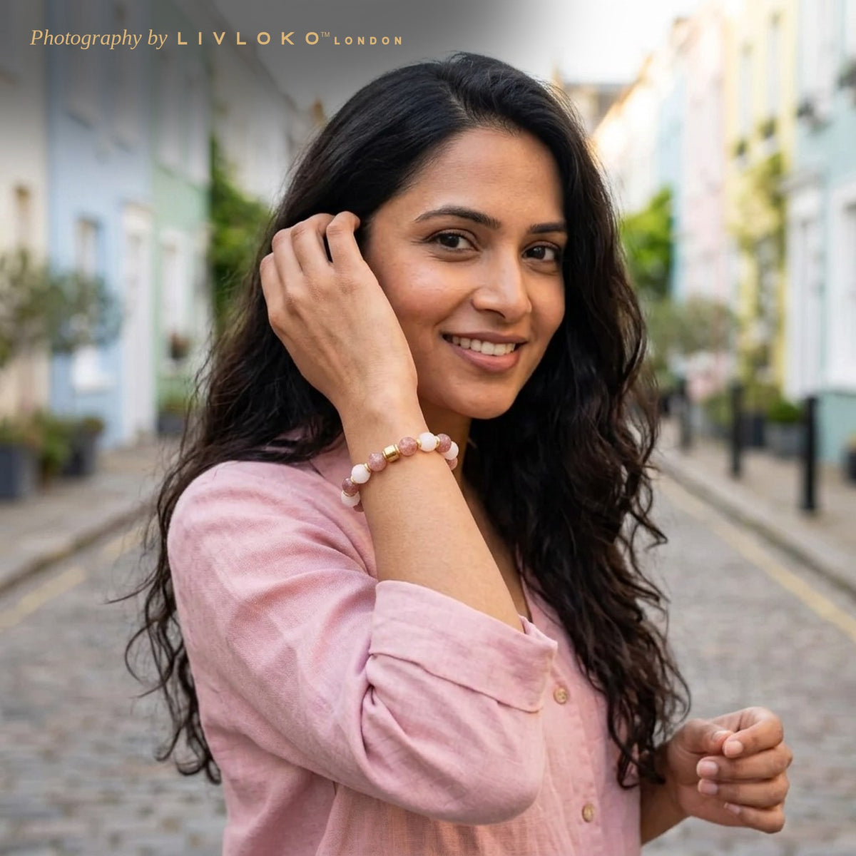 Woman wearing the Livloko London rose quartz and strawberry quartz bracelet on a Notting Hill street in London