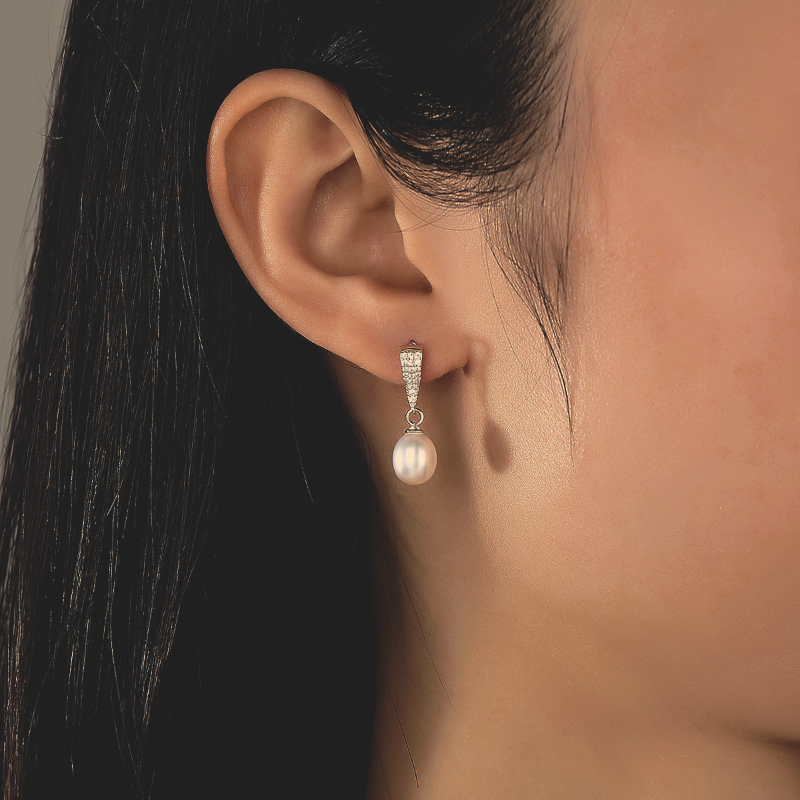 Model wearing Sterling Silver Pearl Drop Earrings with Tapered Detail