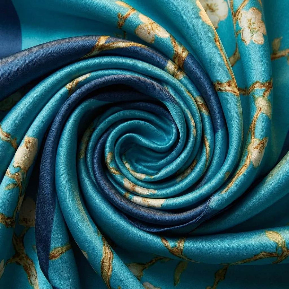 Close-up of the light blue satin scarf swirled to show the turquoise blossom print and dark border