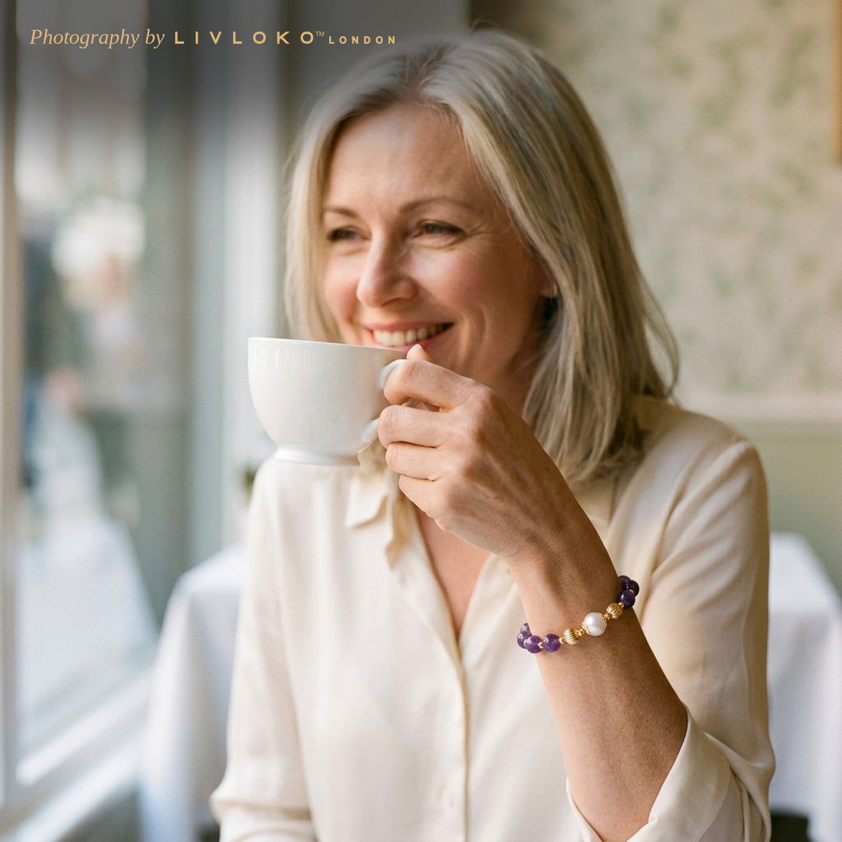 Woman wearing the Livloko London amethyst and freshwater pearl bracelet at afternoon tea in London