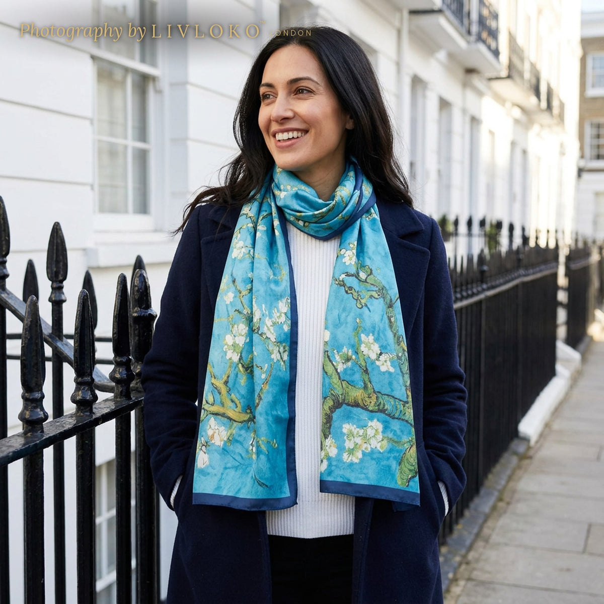 Woman wearing the Azure Blossom blue floral mulberry silk scarf on a London street, LIVLOKO LONDON