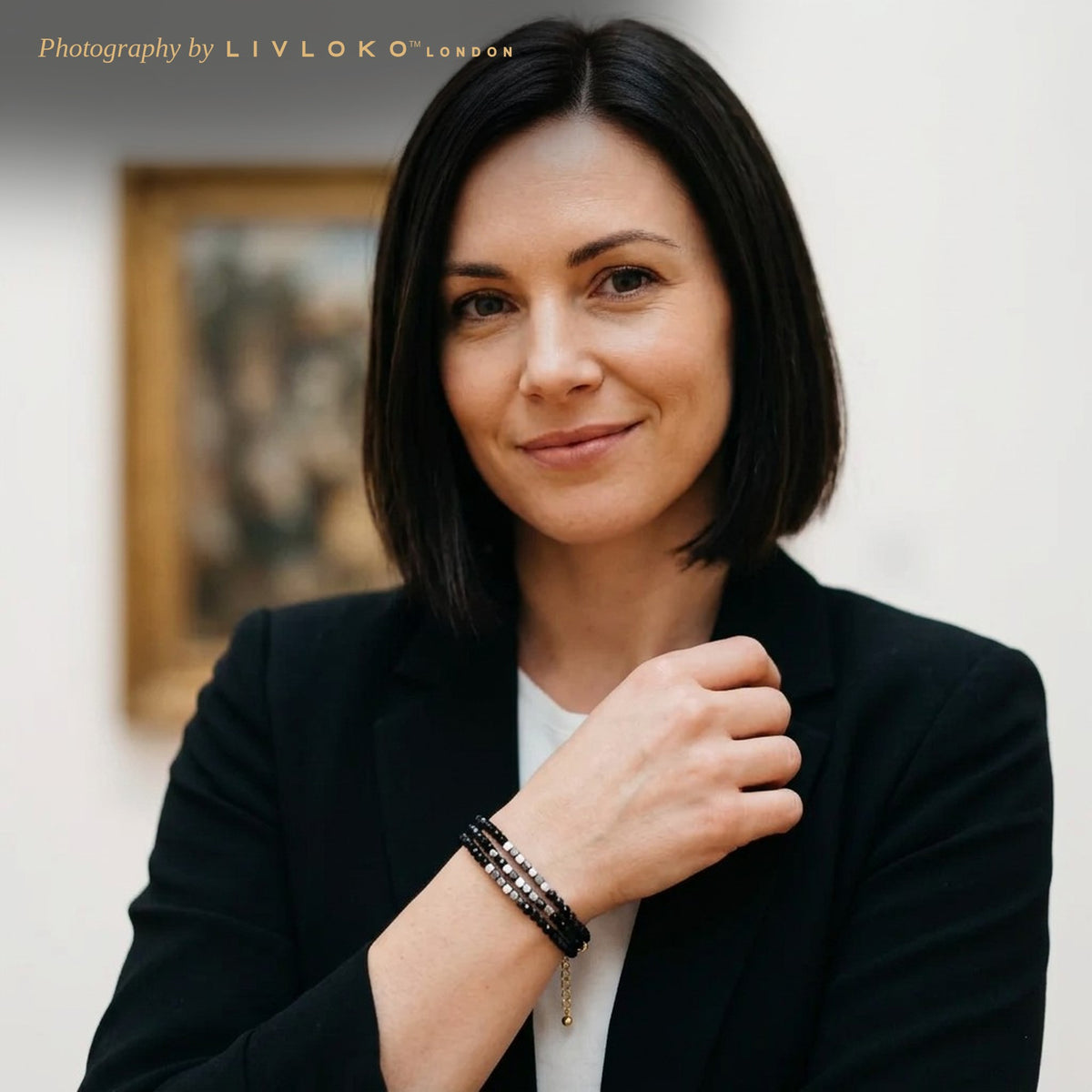 Woman in a black blazer wearing the Livloko London black hematite multi-strand bracelet in a London gallery