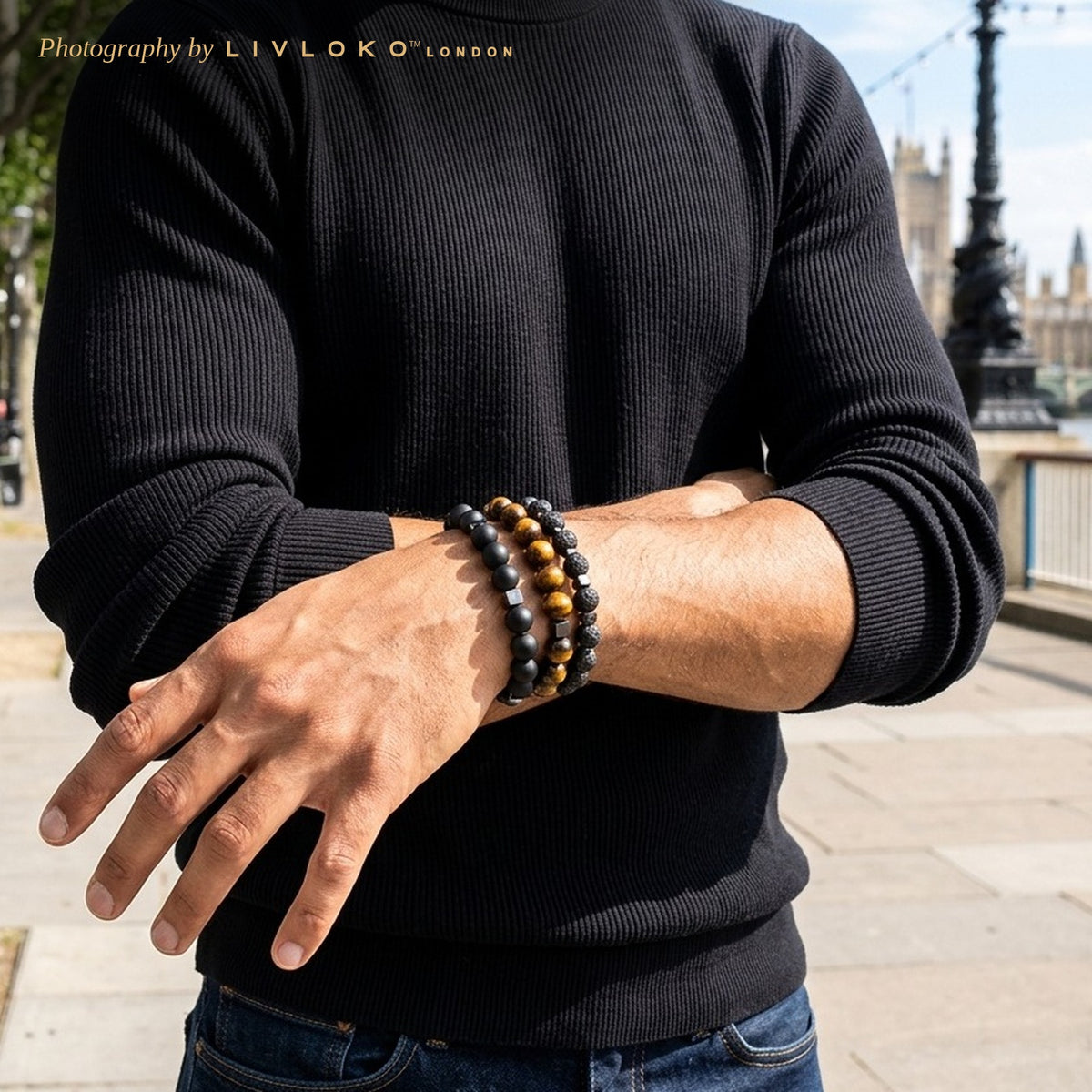 Man wearing the men's beaded bracelet stack on his wrist by the Thames in London