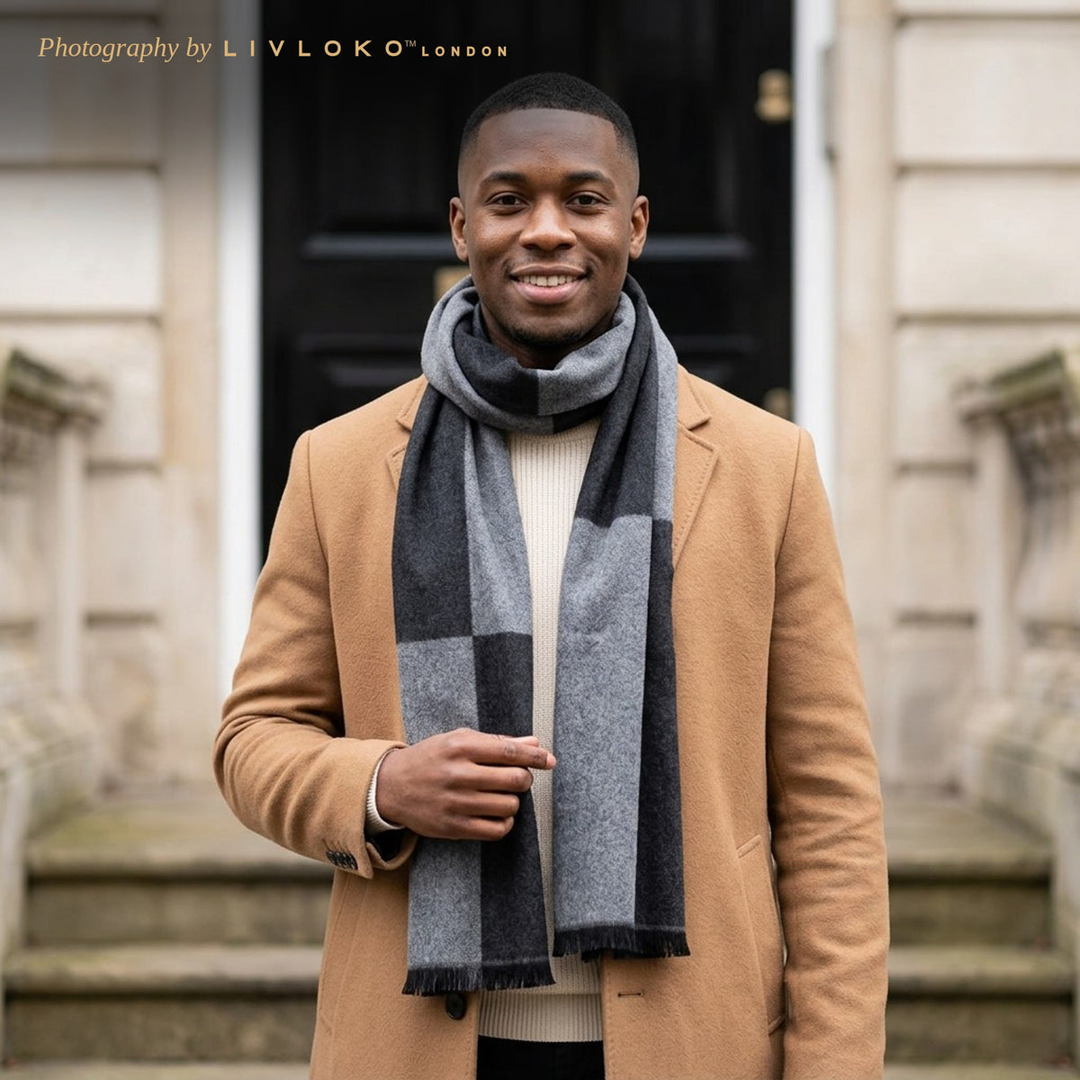Man wearing the LIVLOKO London black and grey large check wool scarf with a camel coat