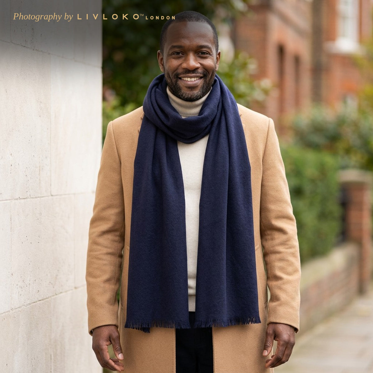 Man wearing the LIVLOKO London navy wool scarf with a camel overcoat