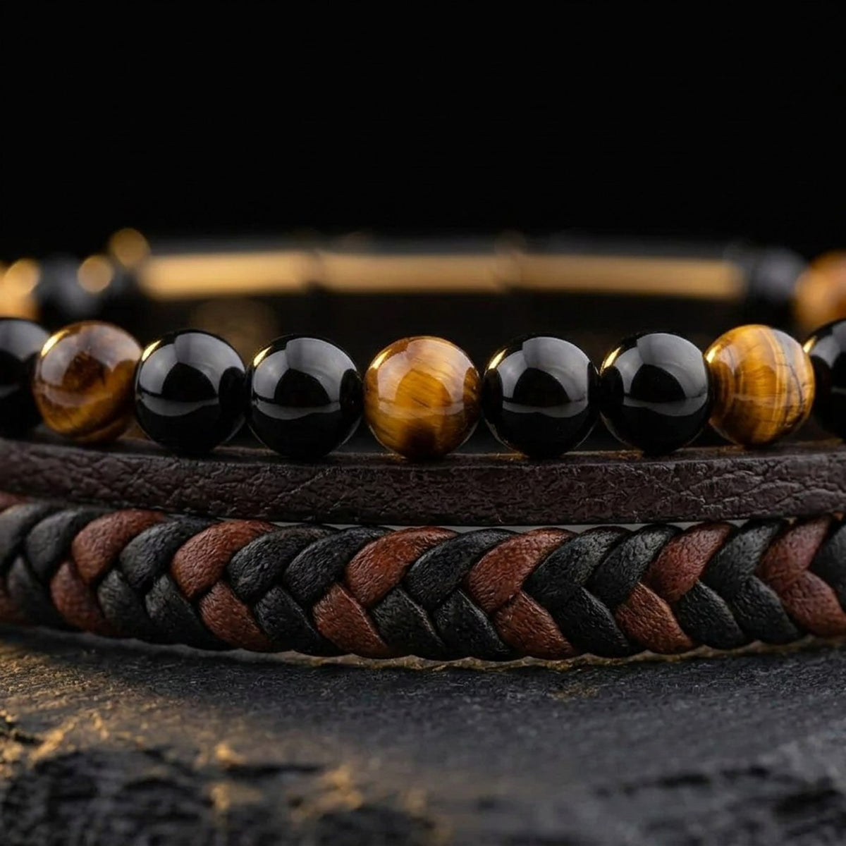 Close-up of genuine tiger eye and black agate gemstone beads with brown and black braided leather