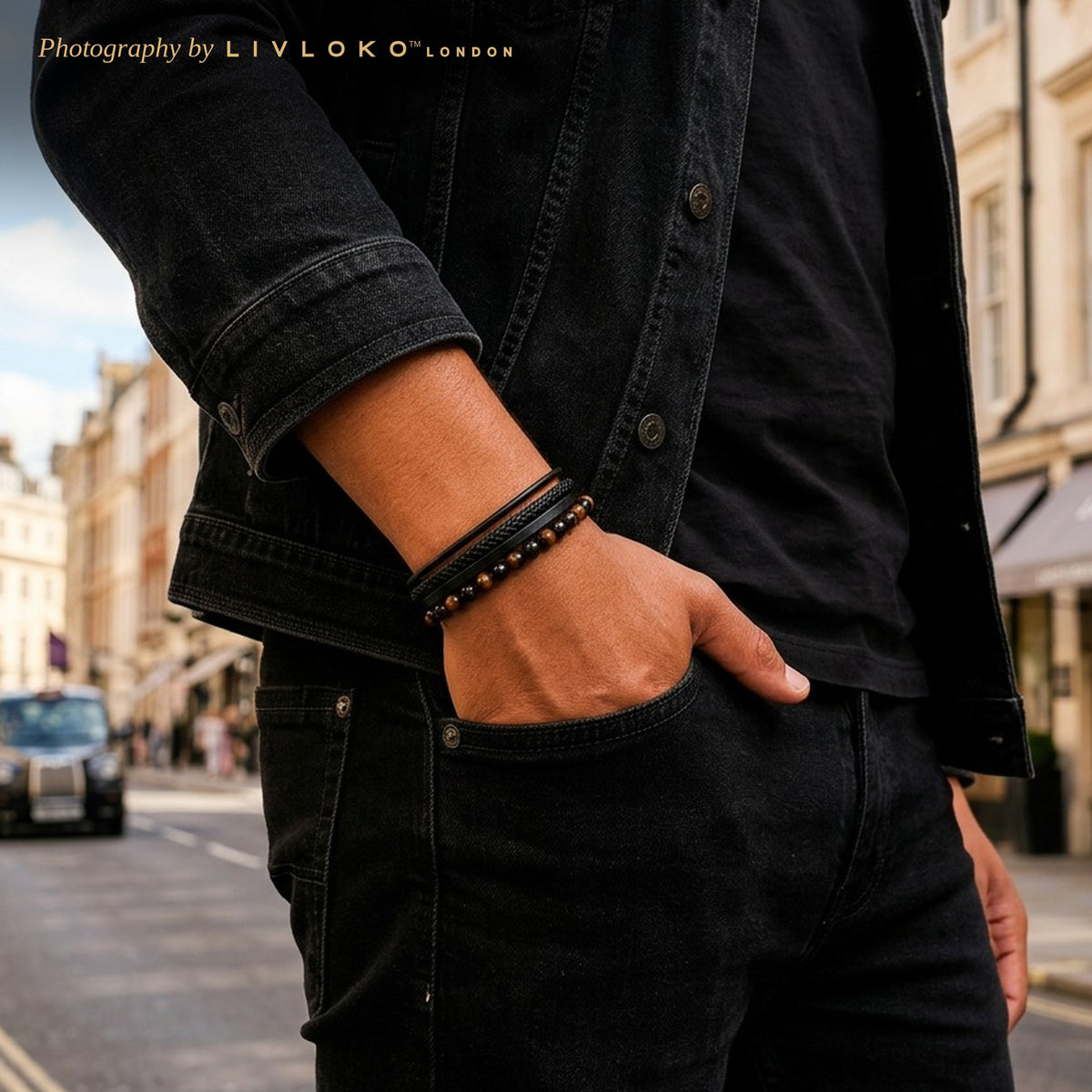 Man wearing the men's tiger eye and black agate leather bracelet with a black denim jacket in London