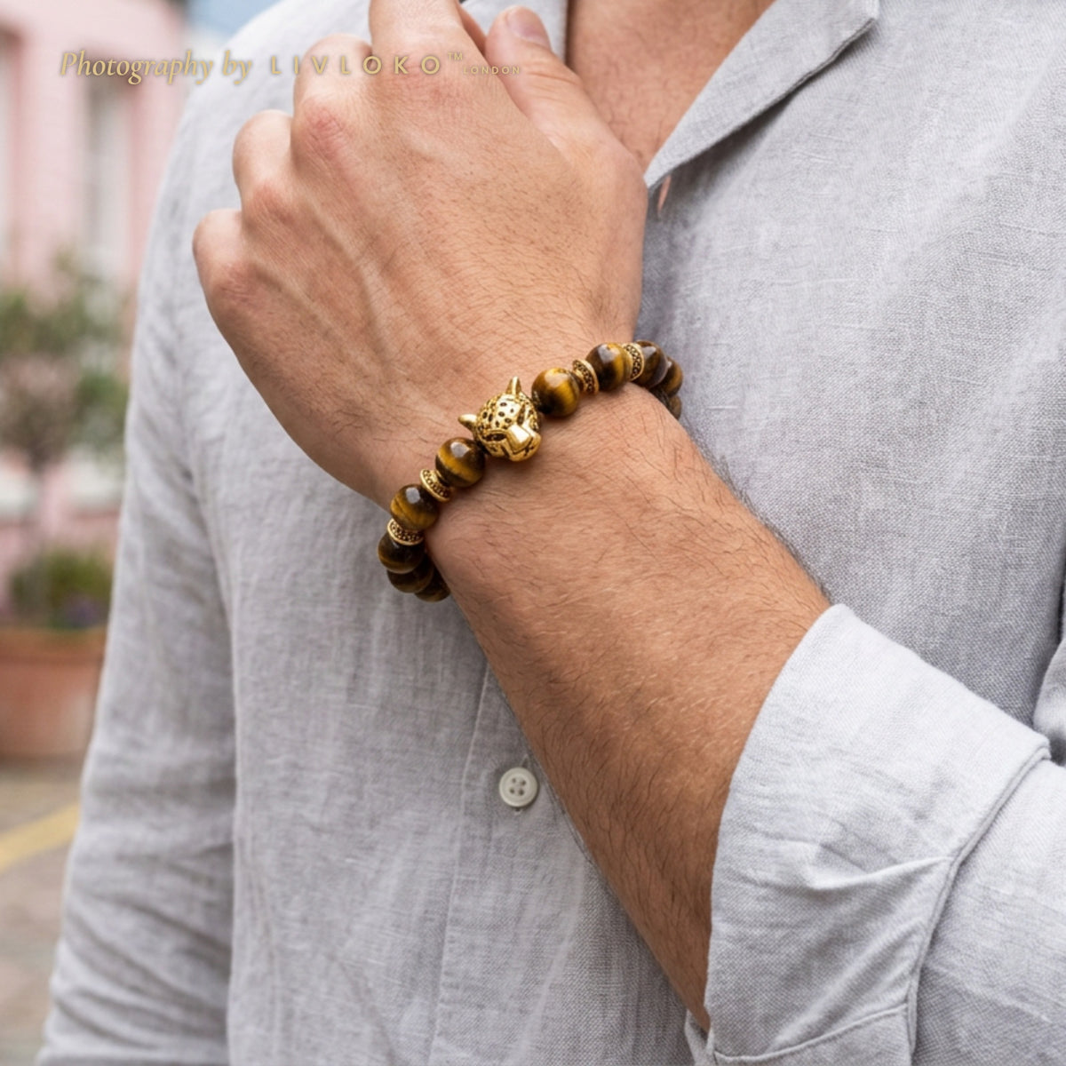Men's tiger eye beaded bracelet with gold leopard charm worn on the wrist