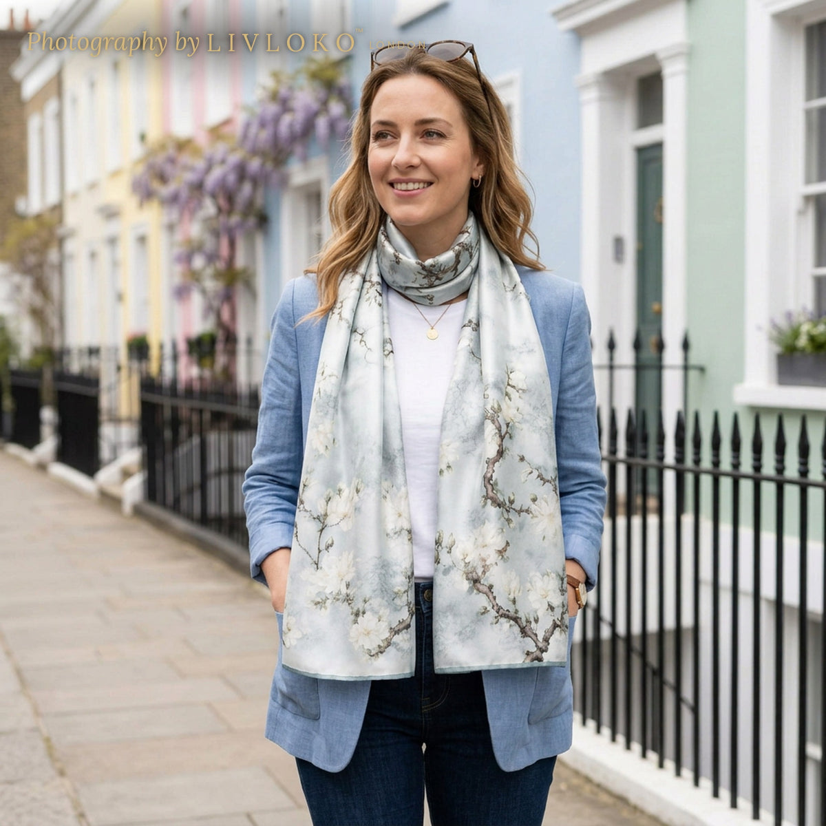 Woman wearing the Sky Blossom grey and cream silk scarf wrapped around the neck on a London street