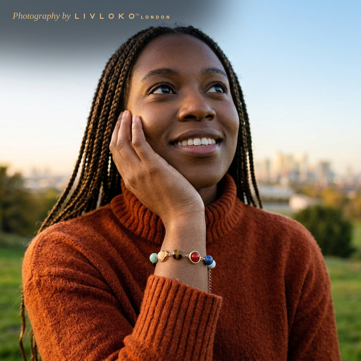 Woman wearing the Livloko London solar system crystal bracelet looking up at the sky in Greenwich Park, London