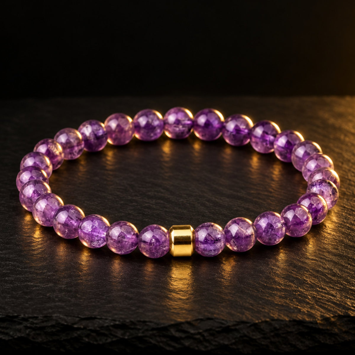 Purple amethyst bead bracelet with a single gold bead on dark slate