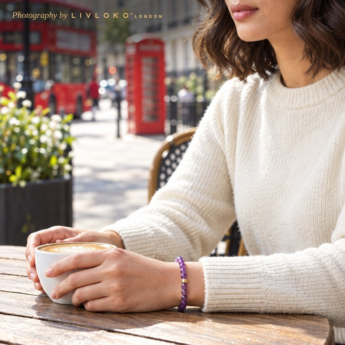 Woman wearing the amethyst bead bracelet at a London café table