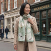 Lotus Breeze sage green mulberry silk scarf worn on a London street, by LIVLOKO London