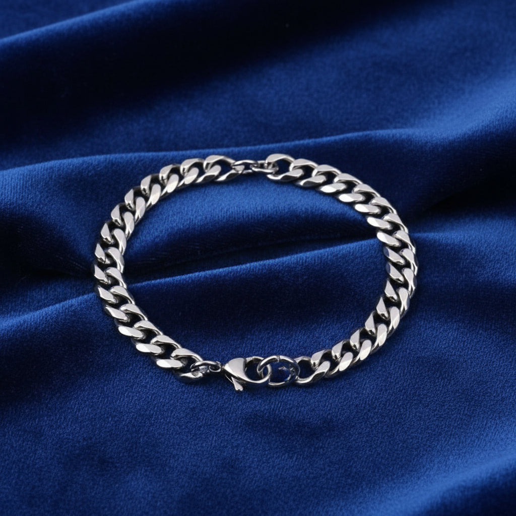 Silver chain bracelet displayed on deep blue fabric surface