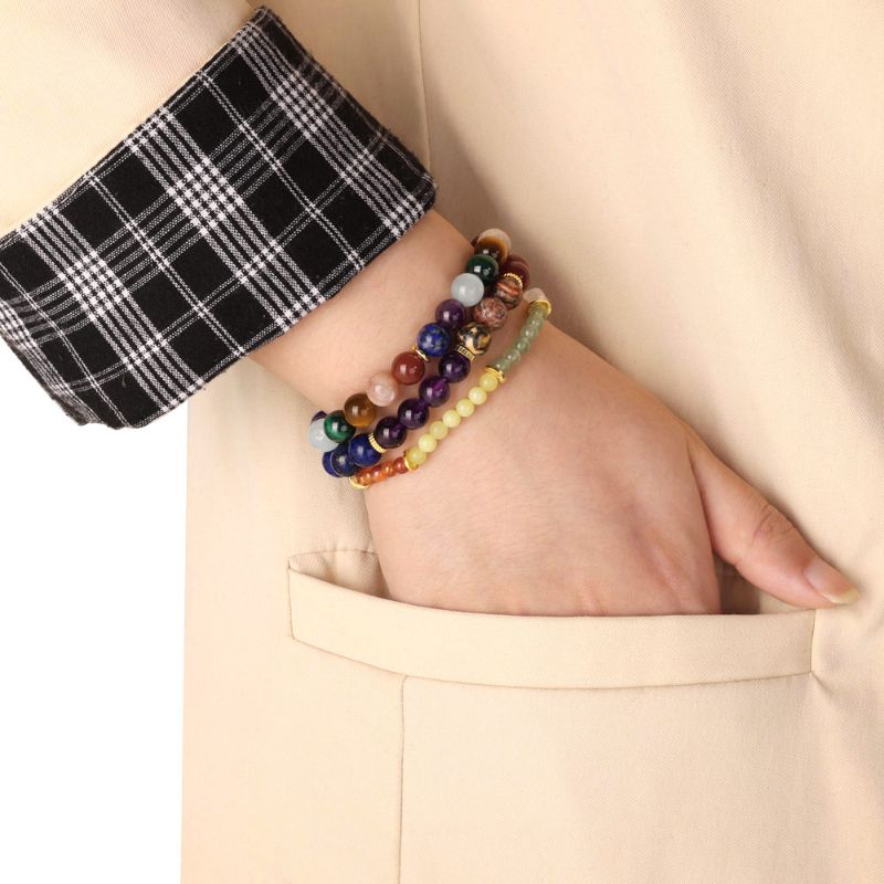 Stacked 7 Chakra Bracelets around woman's wrist