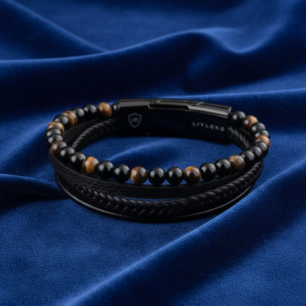 Black leather bracelet set with tiger eye beads displayed on blue fabric