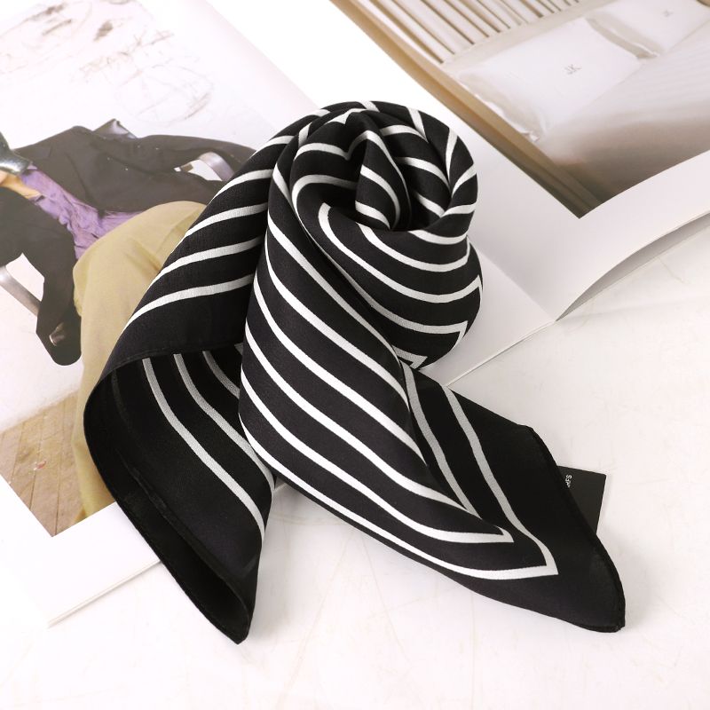Black and white silk scarf rolled on magzine